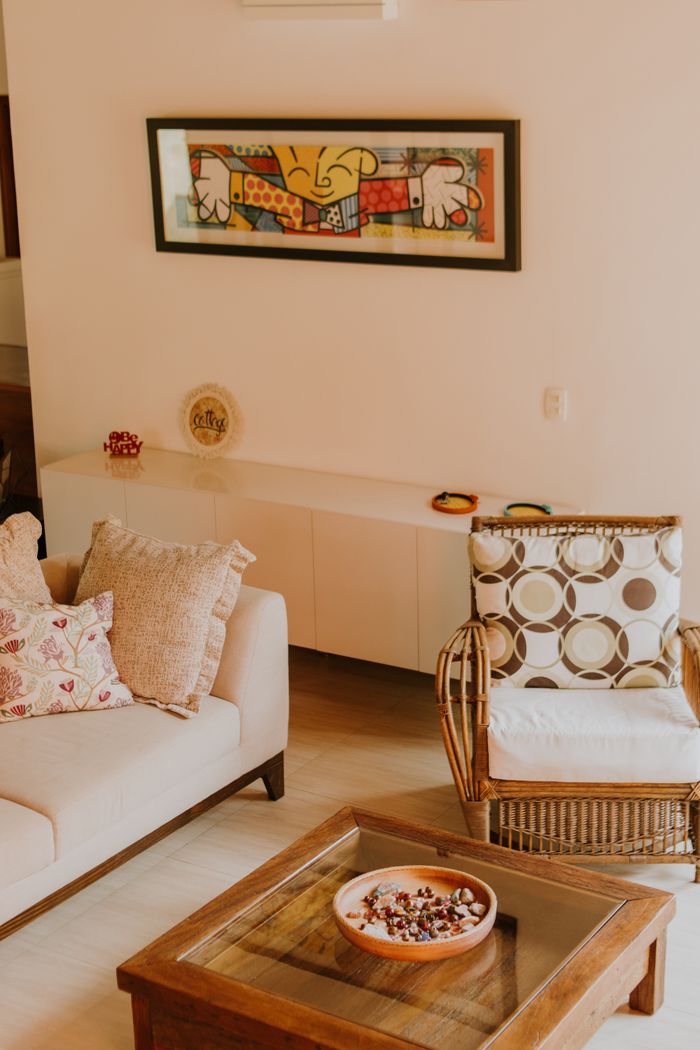 Sitting room with a rattan chair and hung artwork — photo by juliane Monari on Pexels