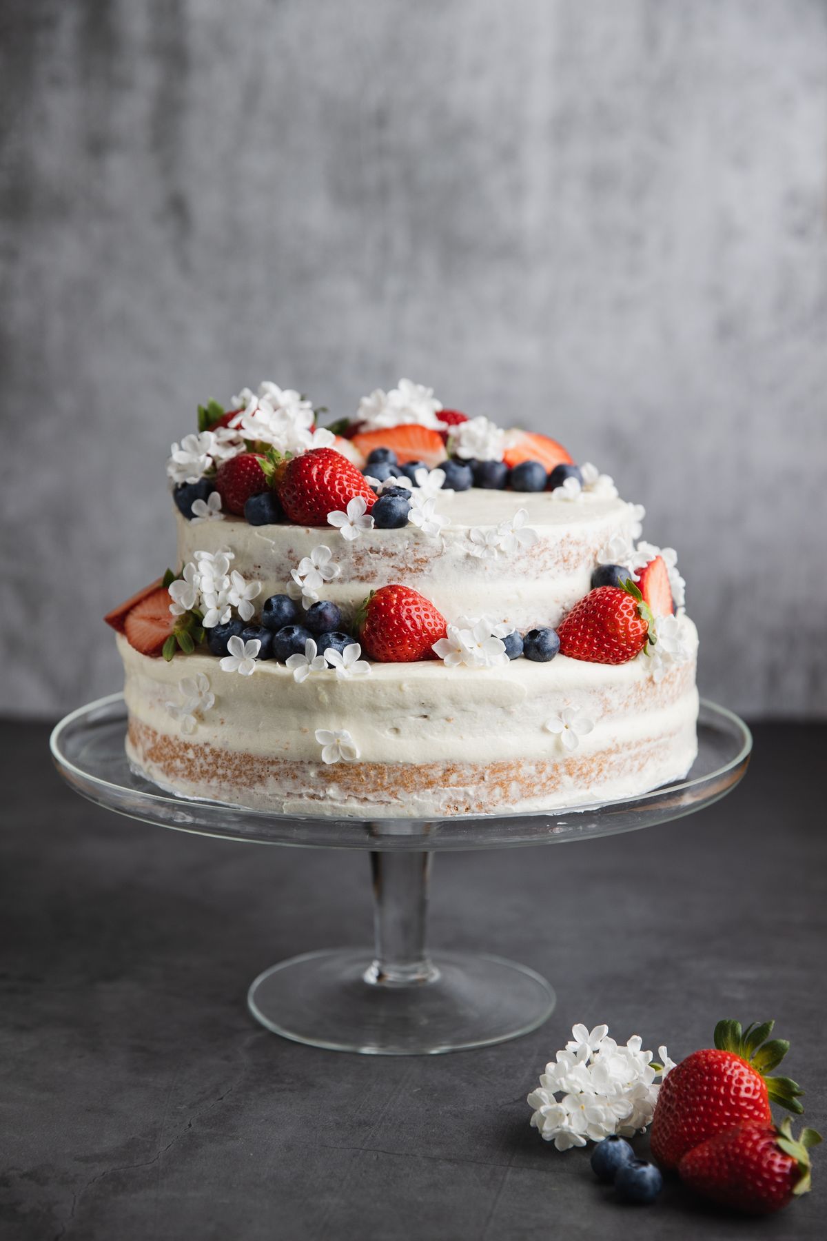 Naked cake topped with fresh strawberries and blueberries