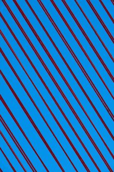 Abstract close-up of red diagonal lines on a vibrant blue background with a modern aesthetic.