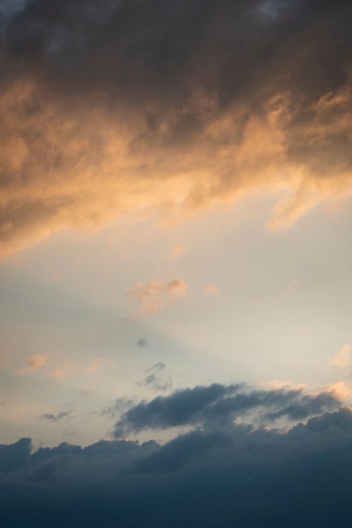 Free A dramatic cloudscape at sunset, showcasing vibrant orange and blue hues in the sky. Stock Photo