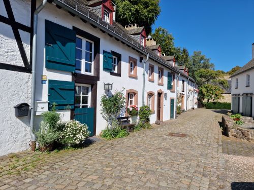 Free Picturesque European street with charming whitewashed houses and vibrant shutters. Stock Photo