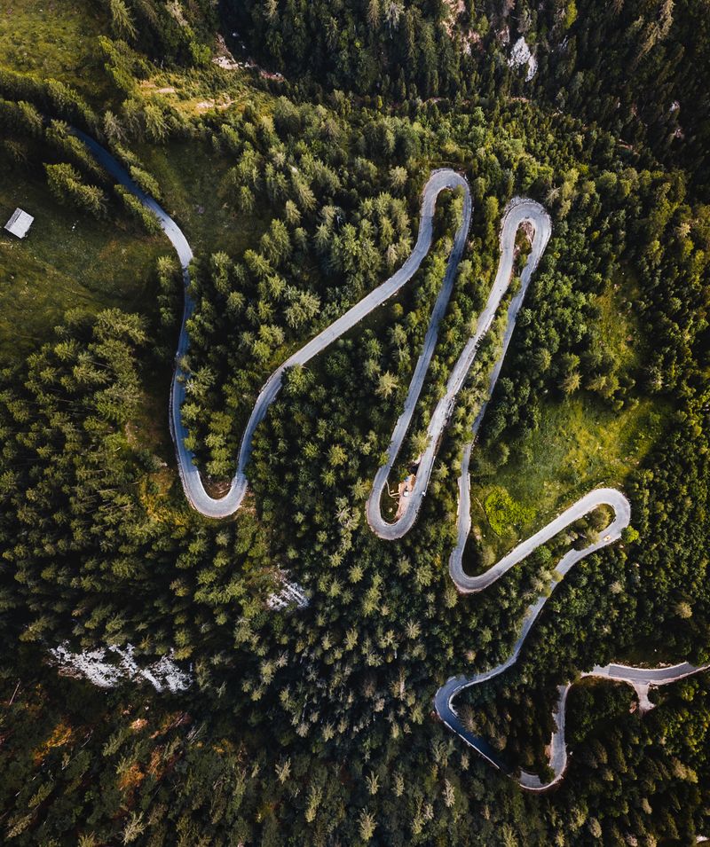 Aerial view of a winding two-lane road curving through green terrain