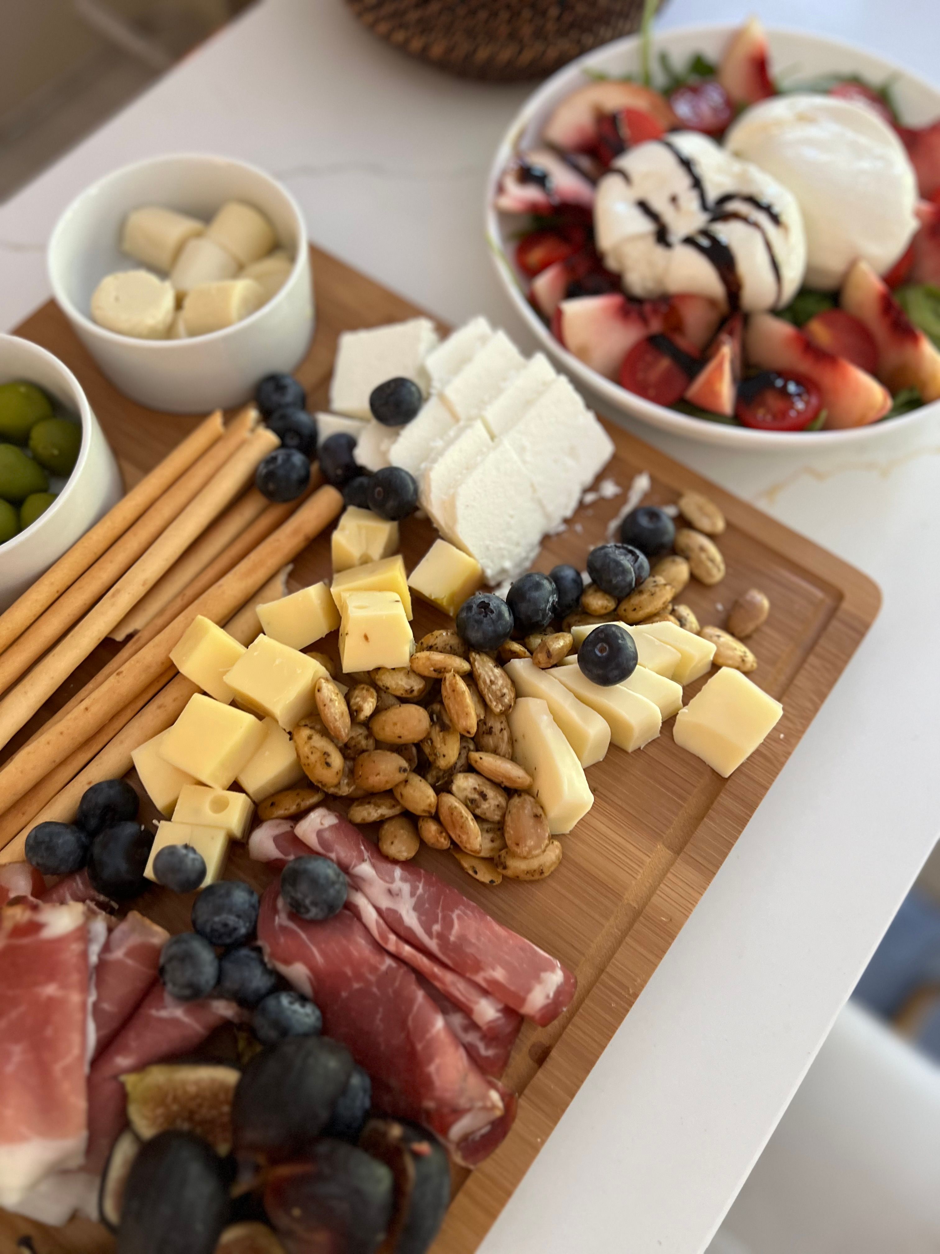 Italian charcuterie board with cured meats, cheeses, and appetizers on white serving platter