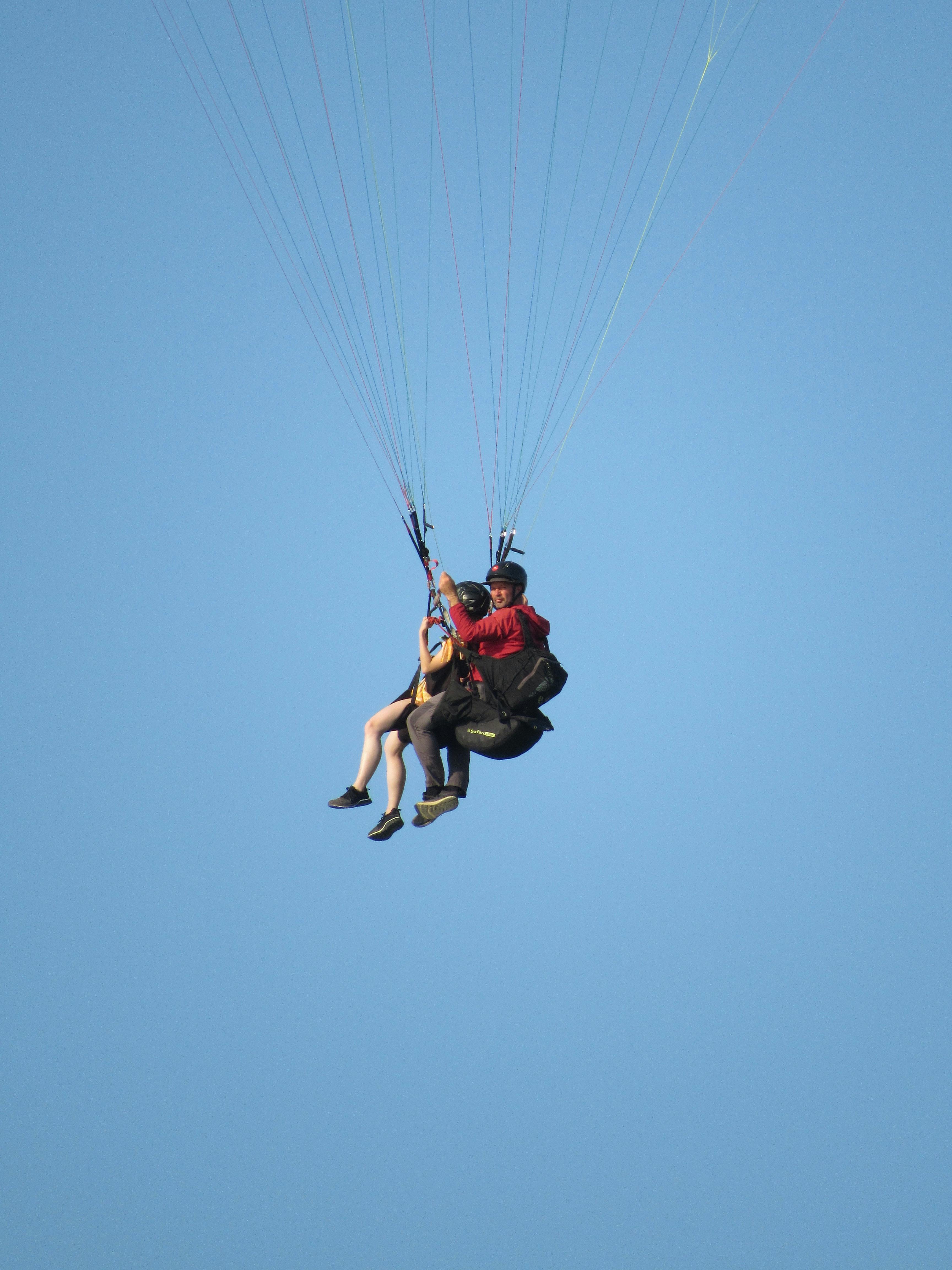 tandem paragliding in clear blue sky