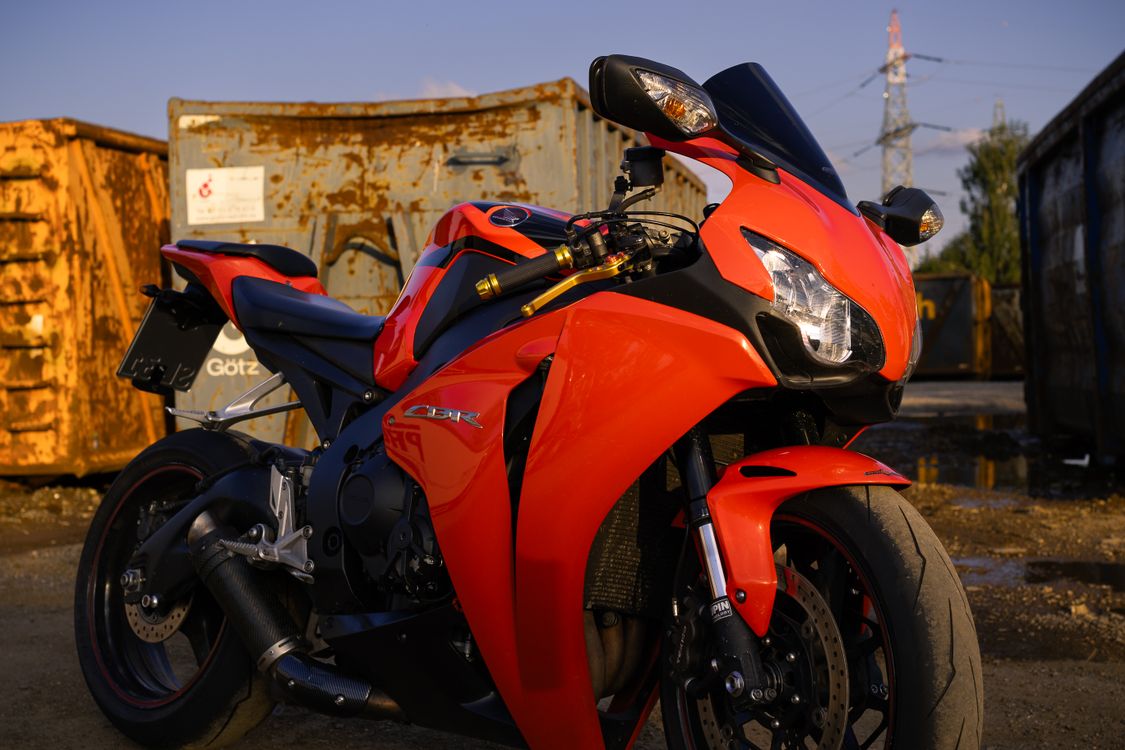 Vibrant Red Motorcycle in Industrial Setting · Free Stock Photo