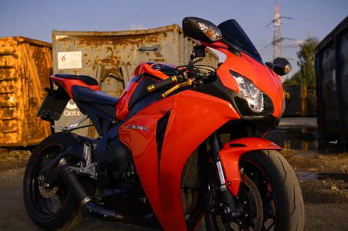 Free Close-up of a red sport motorcycle parked outdoors in an industrial area. Stock Photo