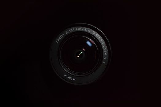 High-quality close-up image of a DSLR camera lens with dark background.