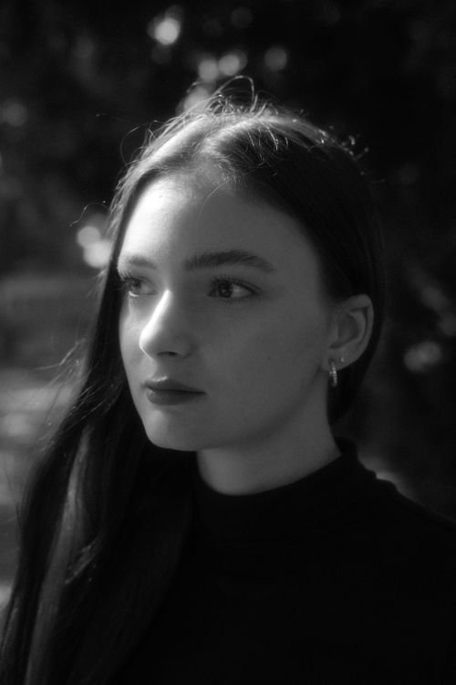 Free Black and white portrait of a young woman with flowing hair in natural light. Stock Photo