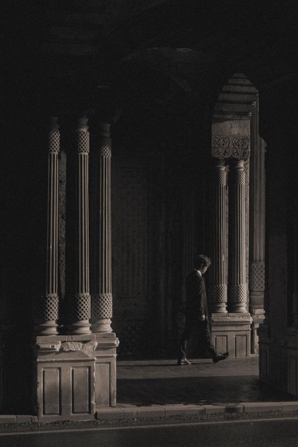 Moody black and white photograph of Ottoman architecture in Istanbul, featuring detailed columns and shadows.