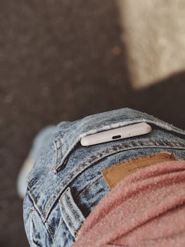 智能手机特写图，部分塞进蓝色牛仔裤后口袋