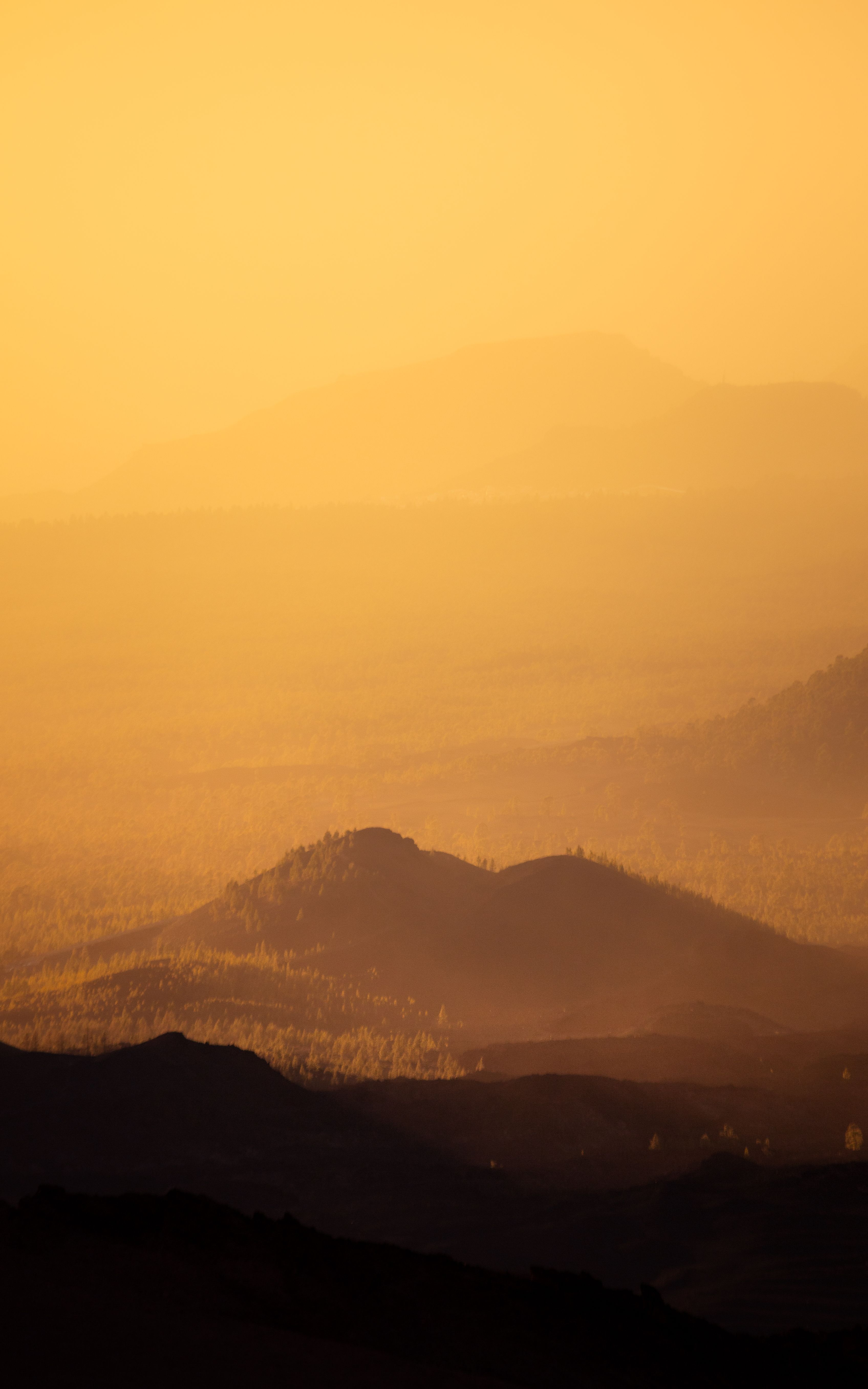 Captivating sunset with warm hues over Tenerife's rugged mountain landscape.