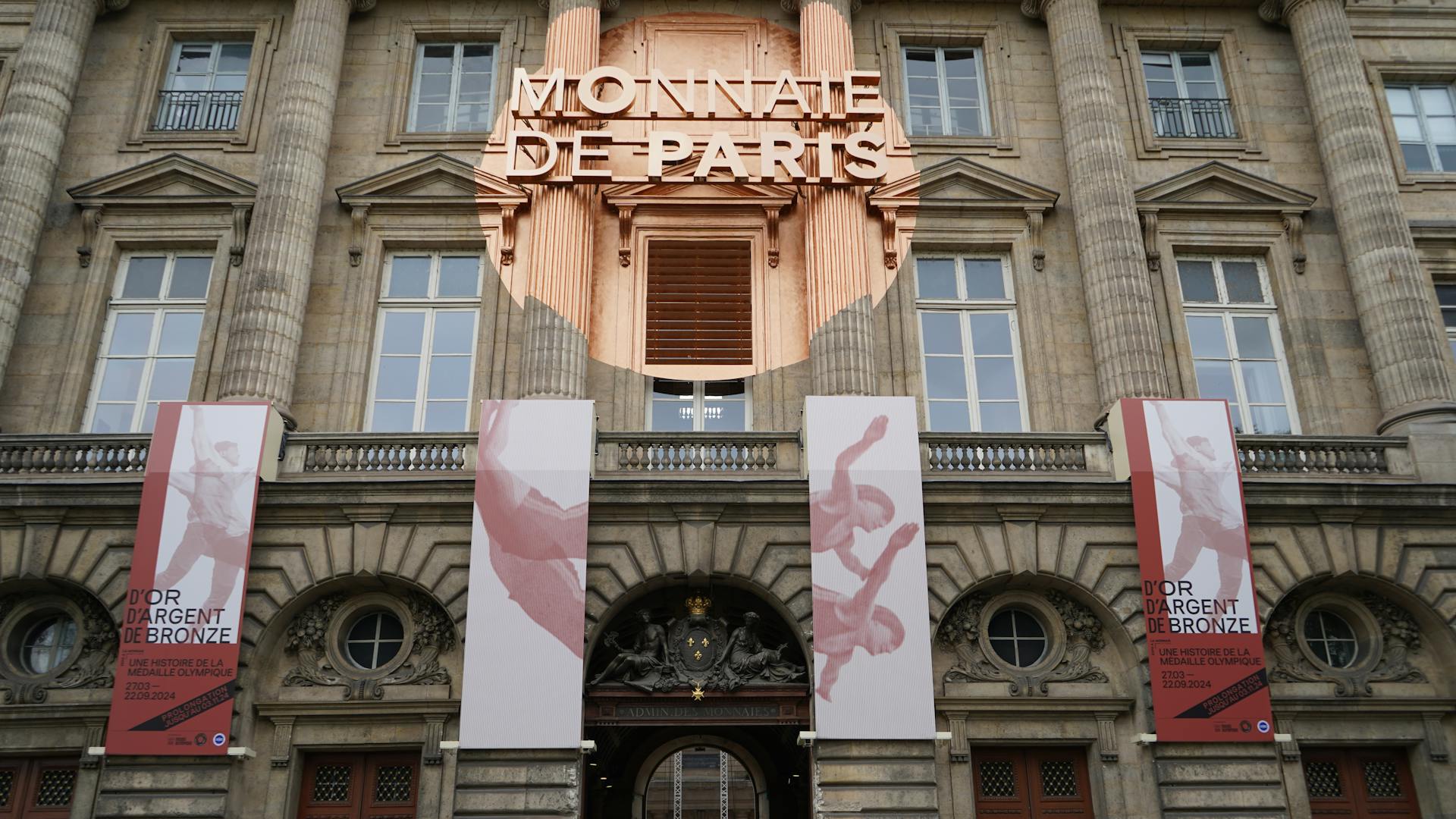 Front view of Monnaie de Paris with decorative banners on the facade.