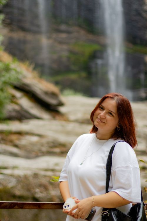 Free A woman poses happily in front of a scenic waterfall in Bursa, Türkiye. Stock Photo