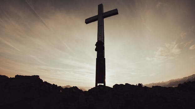Silhouette of a cross on a mountain peak during sunrise in the Alps, Garmisch-Partenkirchen.