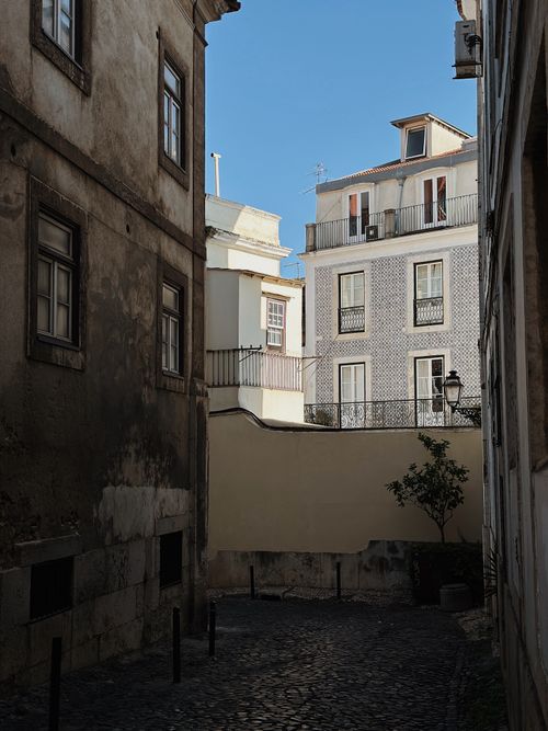Free Narrow alley with classic architecture and a clear blue sky in a historic city. Stock Photo