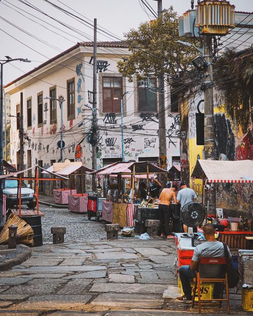 Free A bustling street market in an urban area with colorful stalls and local graffiti. Stock Photo