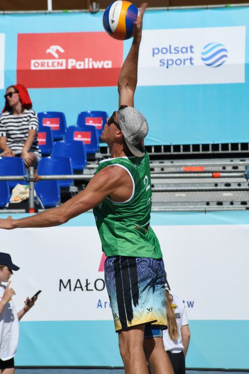 Free Athlete jumps for a volleyball in intense beach game in Kraków. Stock Photo