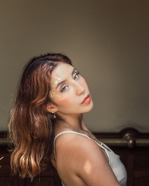 Free Captivating portrait of a young woman with artistic makeup, soft lighting, and an elegant pose. Stock Photo