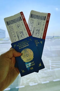 A Kazakhstan passport holds two airline tickets against an airport backdrop in Warsaw, Poland.