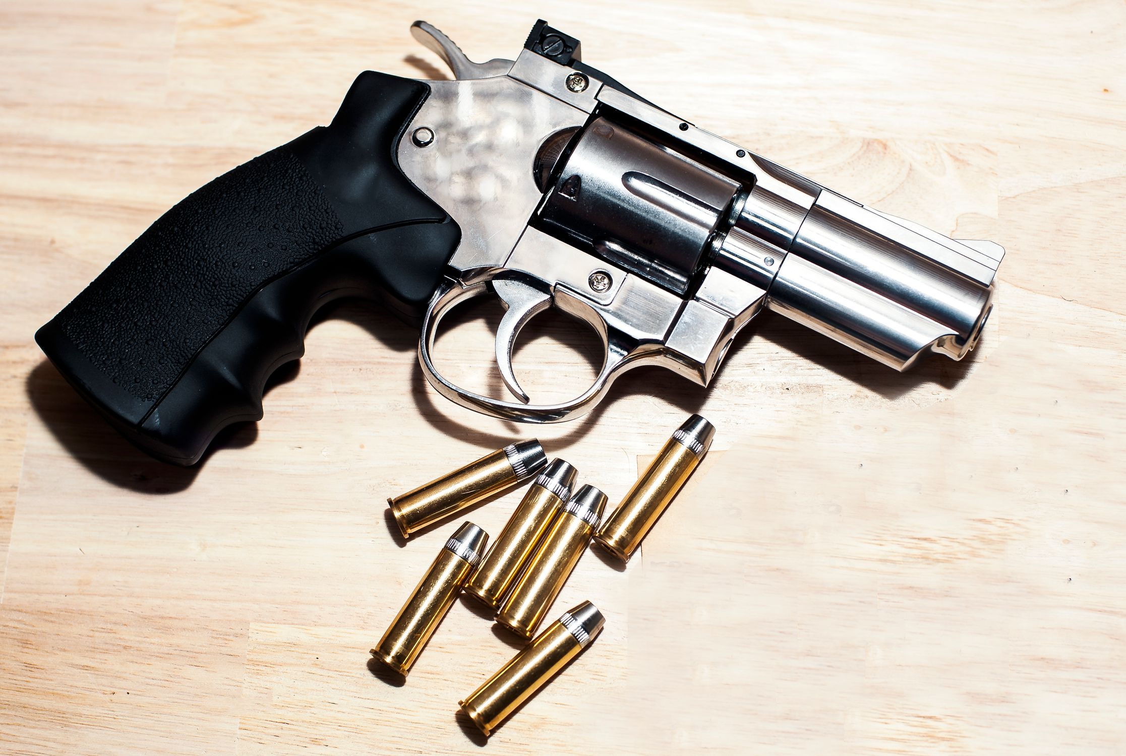 Close-Up of Silver Revolver with Bullets on Wooden Surface · Free Stock ...