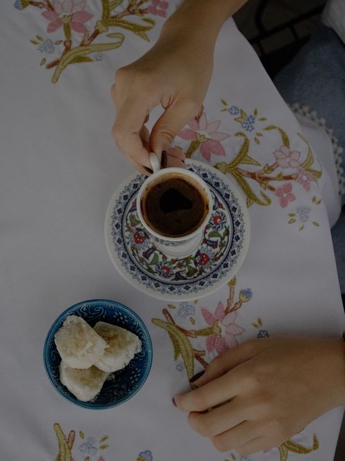 Free A cup of Turkish coffee with Turkish delight on a floral tablecloth, showcasing cultural heritage. Stock Photo