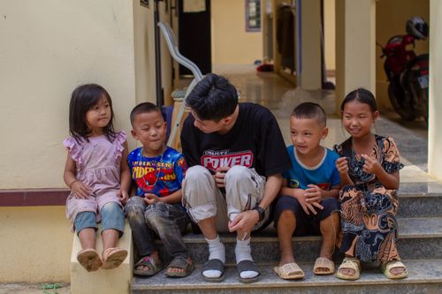 Free Five children and an adult sitting on outdoor steps, smiling and interacting. Stock Photo