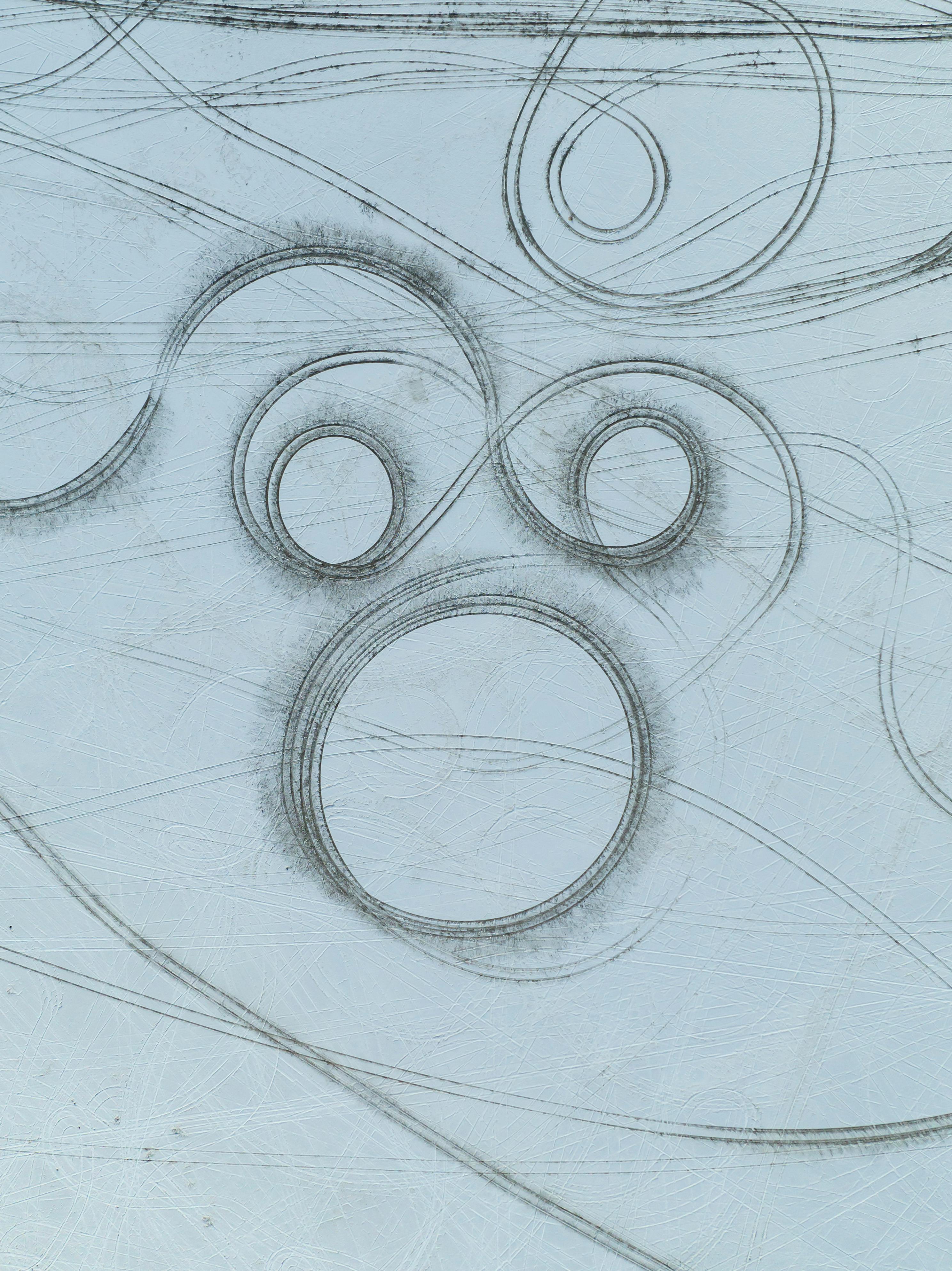 Aerial abstract patterns on a frozen lake's icy surface, showcasing natural artistry.