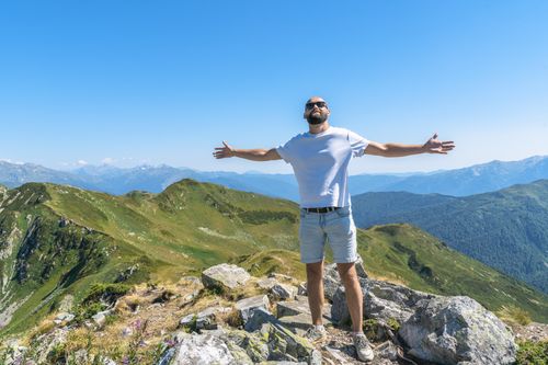 Free A man enjoying the stunning mountain view with open arms, capturing freedom in Гагра. Stock Photo