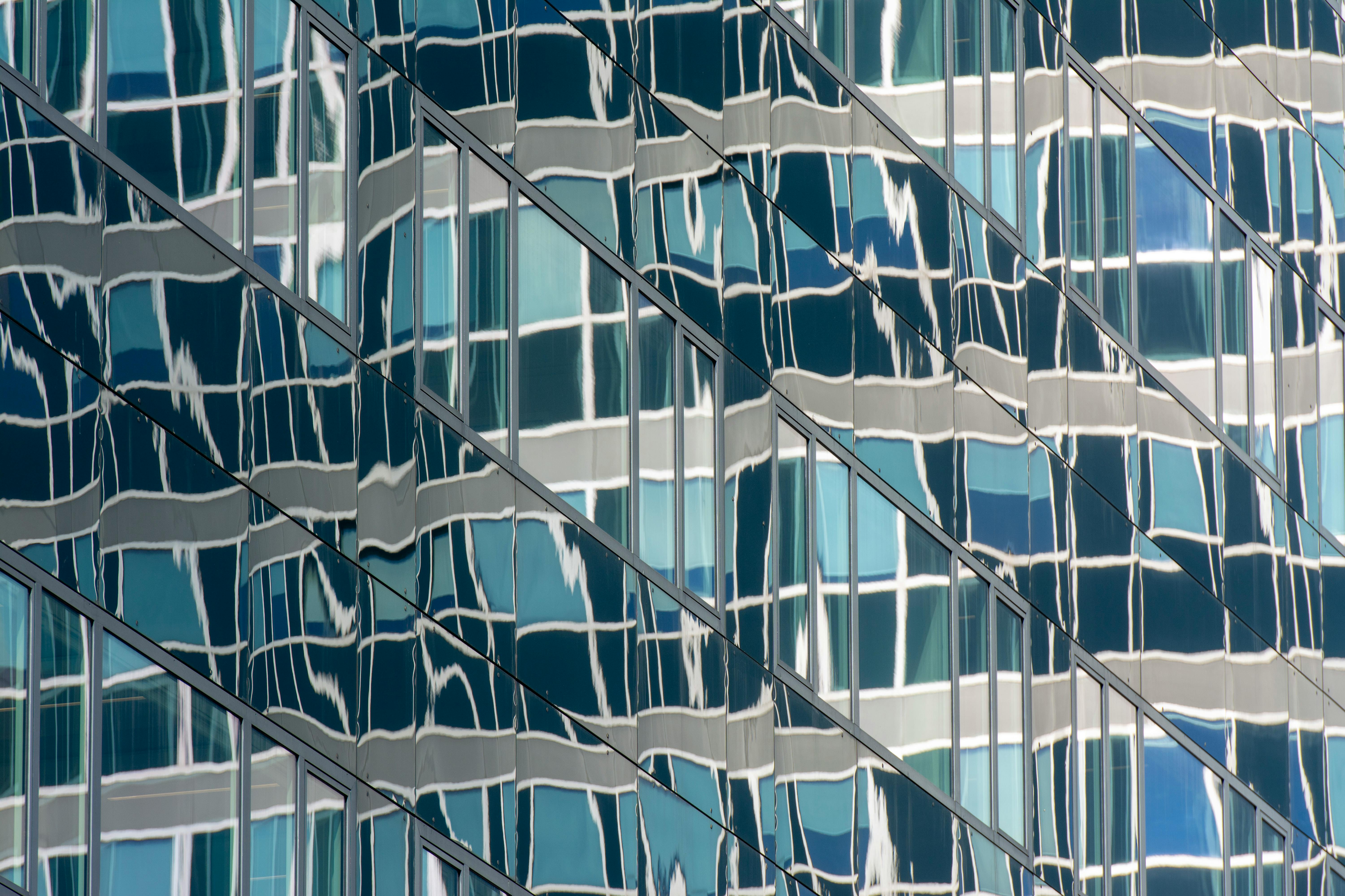 Abstract pattern of reflections on a glass office building facade.