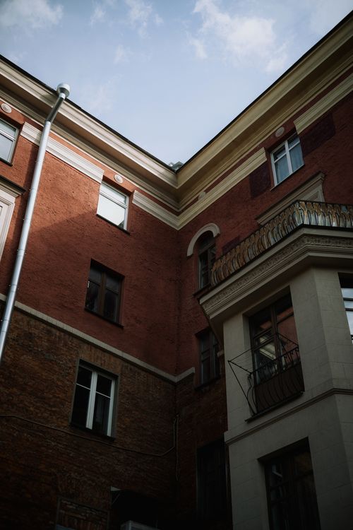Free Rustic red brick facade of a historic building in a Minsk courtyard under a clear sky. Stock Photo
