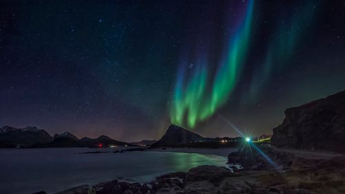 Free Stunning aurora borealis illuminating the night sky over Lofoten Islands with dramatic coastal scenery. Stock Photo