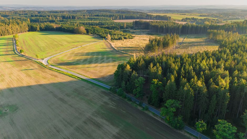 Aerial view of different types of land parcels - raw land, partially improved land, and land with infrastructure