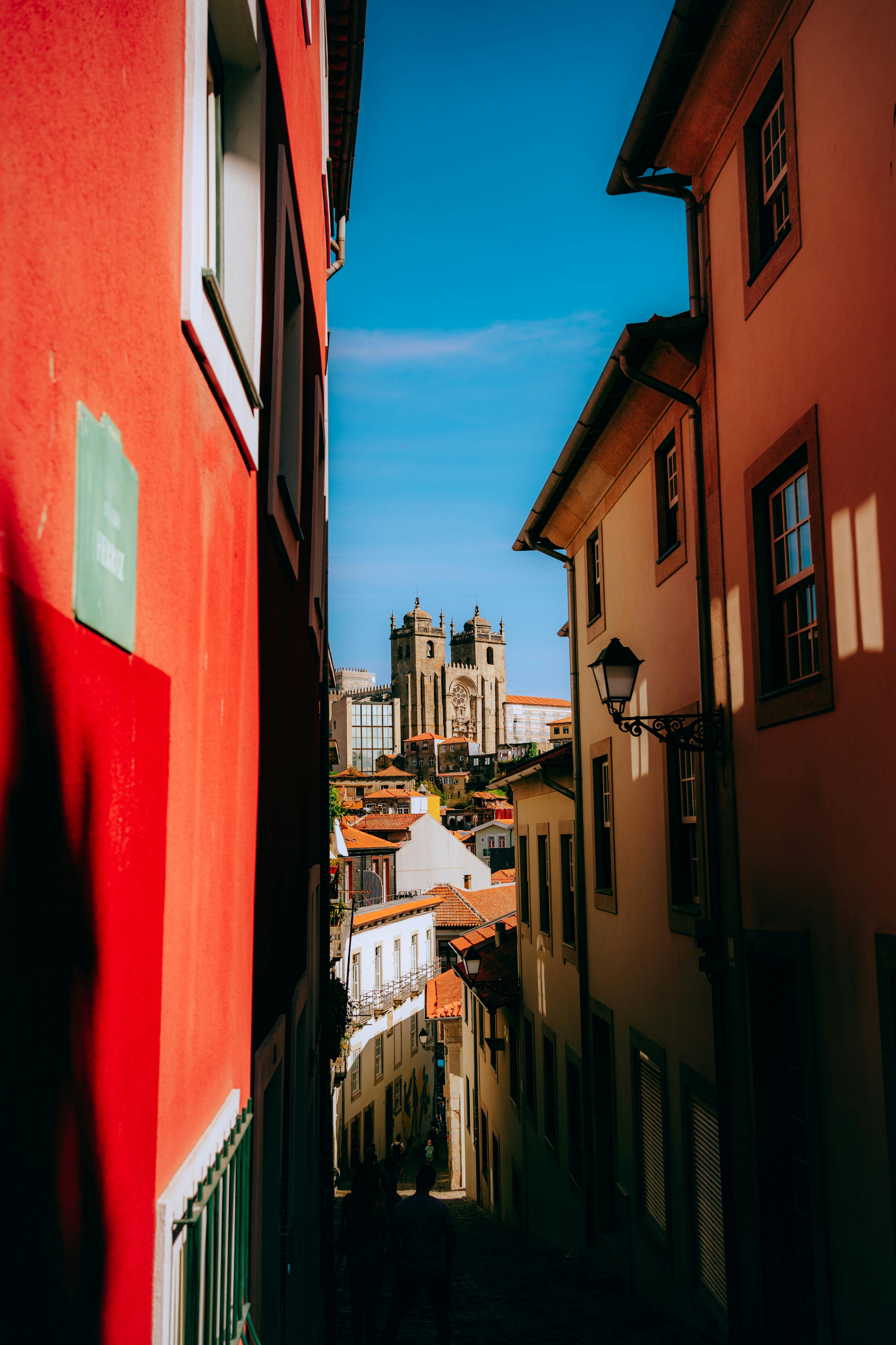 Charming alley in Porto with a view of the historic Porto Cathedral under a clear blue sky.