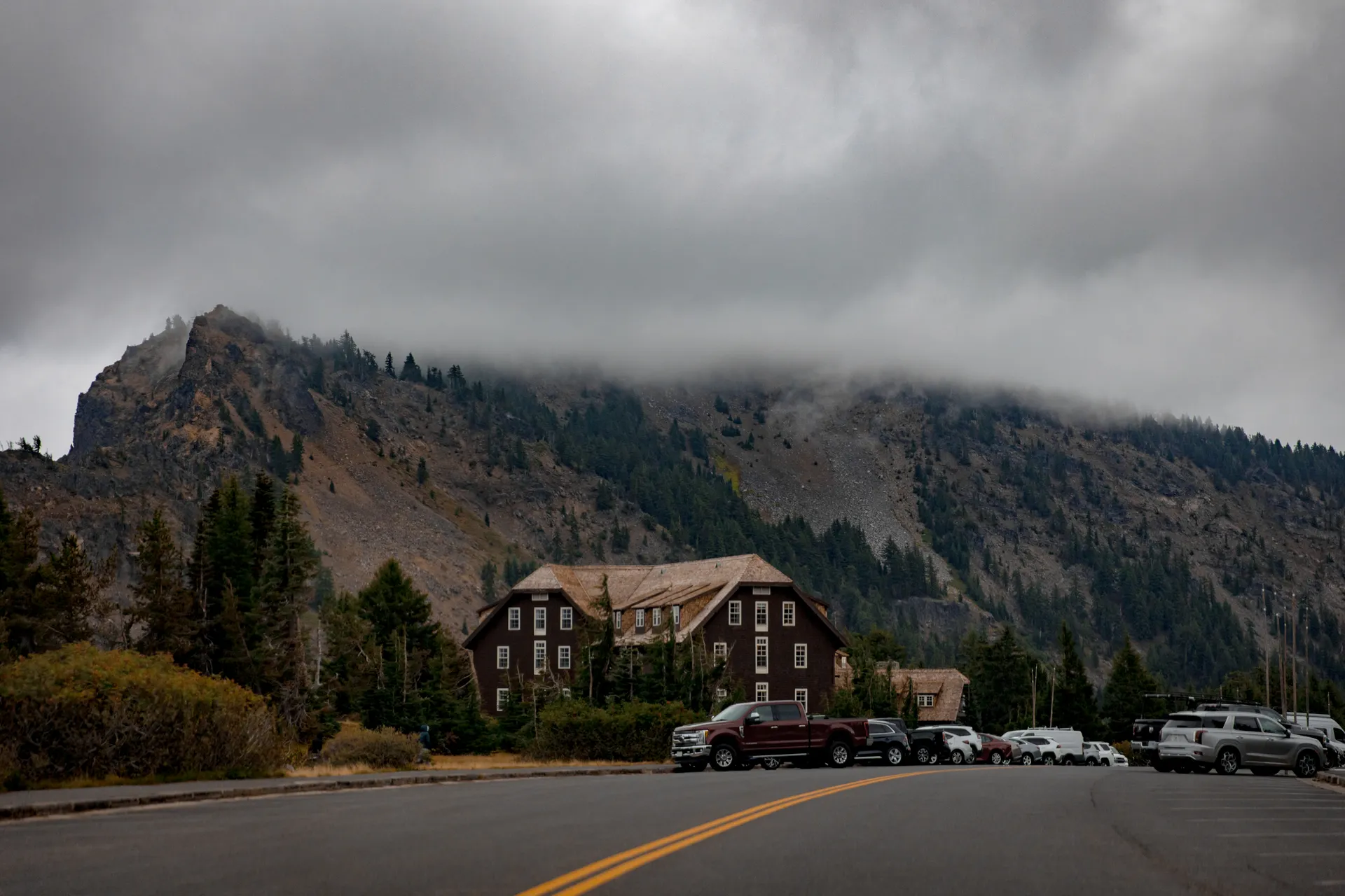 Fog envelops Crater Lake Lodge in Oregon, surrounded by trees and mountains. Fog envelops Crater Lake Lodge in Oregon, surrounded by trees and mountains.