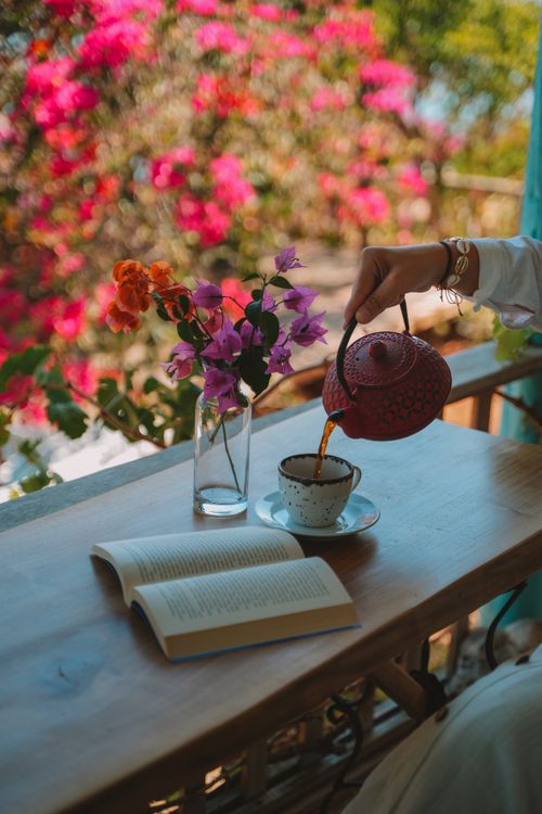 Free Relaxing tea scene with vibrant flowers and a book in Antalya, Türkiye. Stock Photo