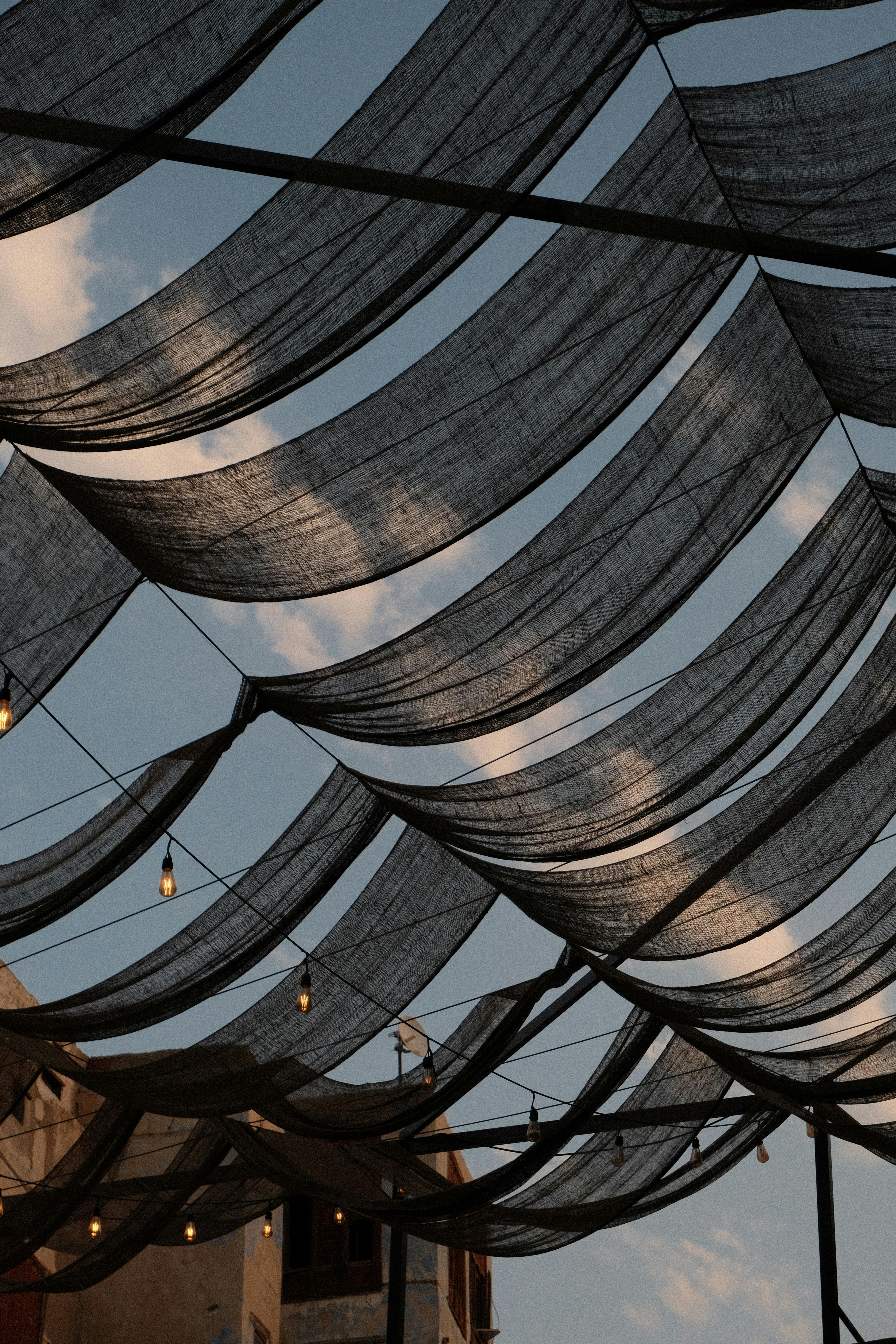 A view of traditional canopies with hanging lights against the evening sky in Jeddah, Saudi Arabia.