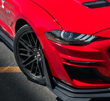 Detailed view of a red sports car front, showcasing its sleek design.
