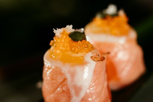 Free Gourmet sushi featuring salmon nigiri topped with roe, captured in a warm, artistic style. Stock Photo