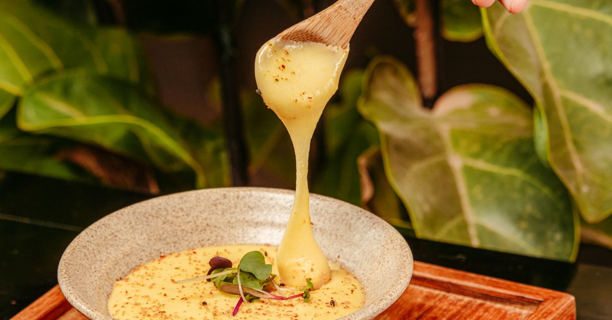 close-up of a savory oatmeal bowl with a perfectly runny yolk and melted cheese