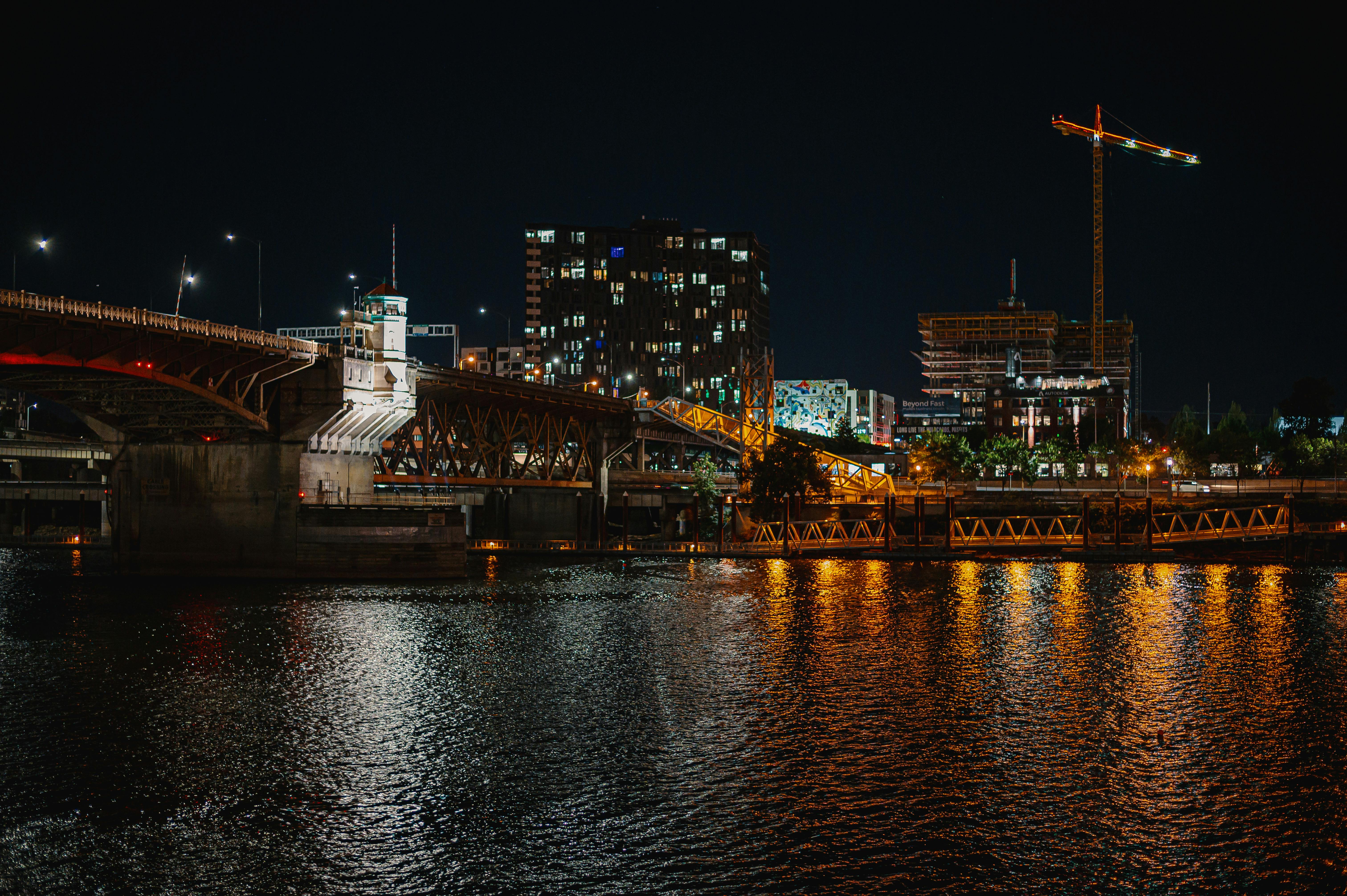 夜色中的城市被照亮，一座桥倒映在河中