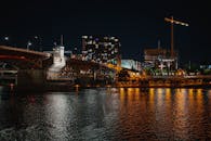 夜色中的城市被照亮，一座桥倒映在河中