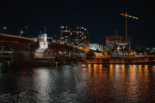 夜色中的城市被照亮，一座桥倒映在河中