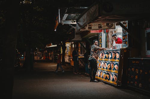 Man Standing In Front Of Food Stall