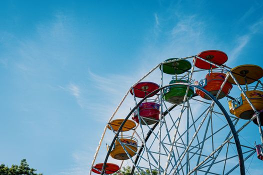 A vibrant Ferris wheel set against a clear blue sky on a sunny day.