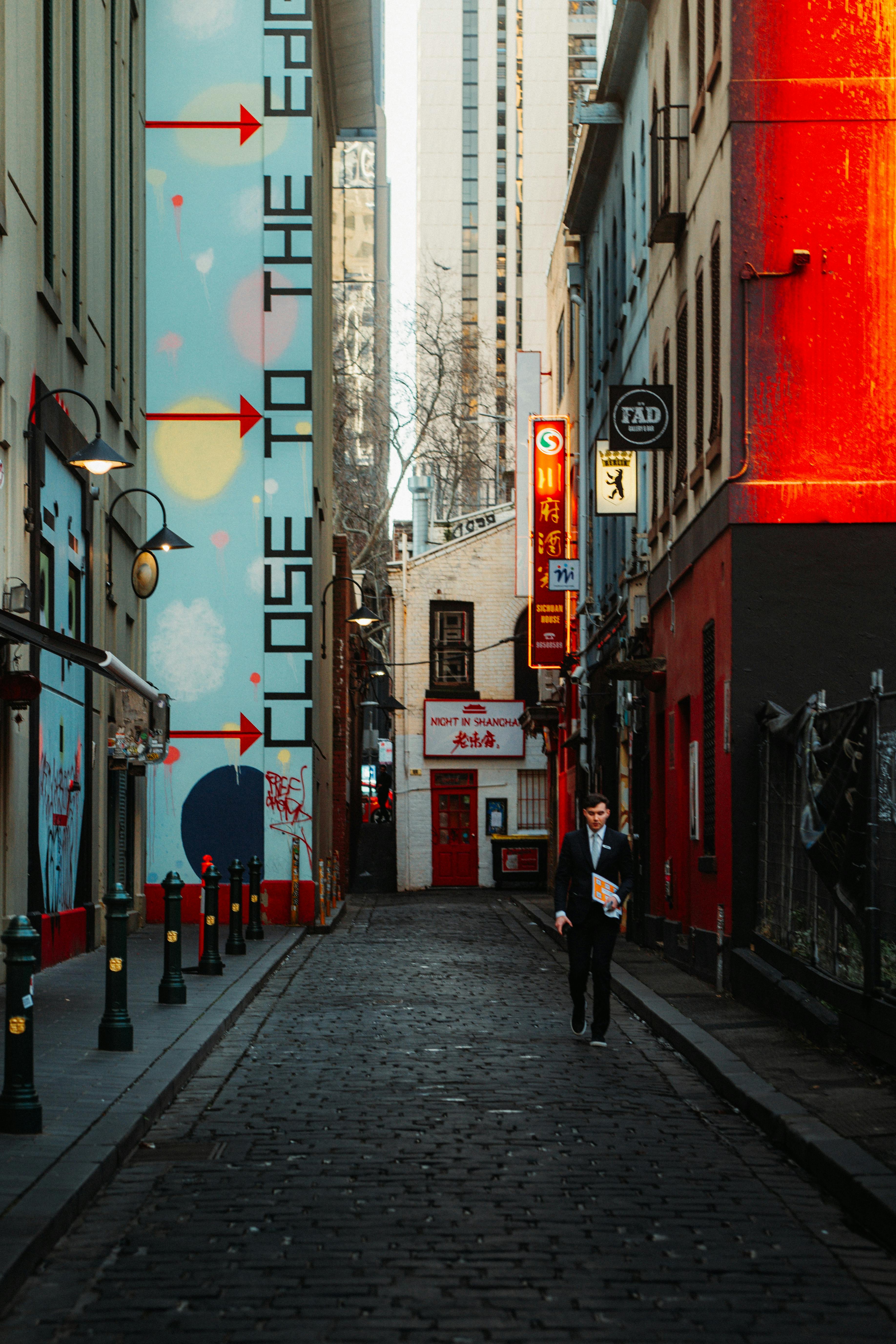 Vibrant alley in Melbourne's Chinatown featuring street art and bright signage.