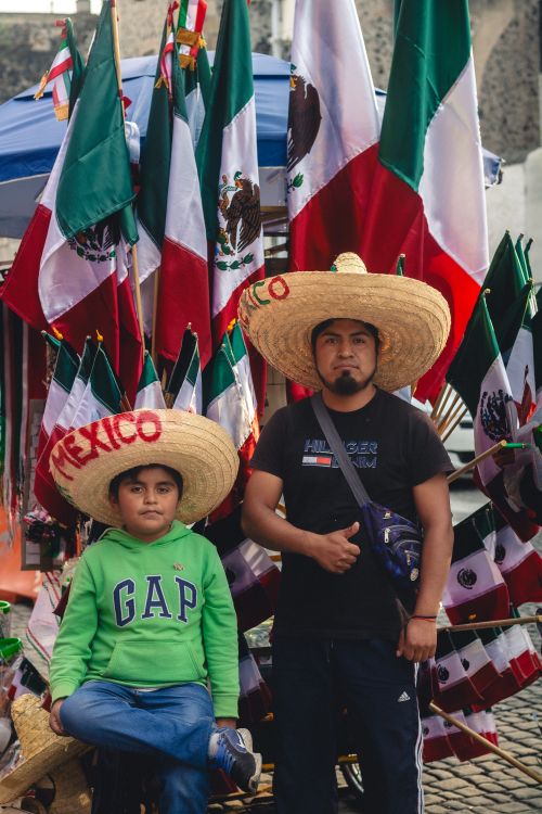 Free Two people celebrate Mexican culture with traditional sombreros and flags in Mexico City. Stock Photo