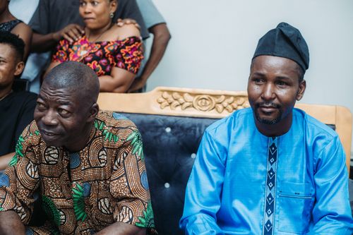 Free Men in traditional attire during a communal gathering indoors, embracing cultural heritage. Stock Photo