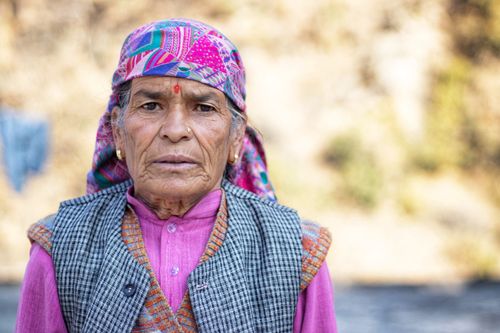 Free Close-up portrait of an elderly woman wearing a colorful headscarf outdoors. Stock Photo