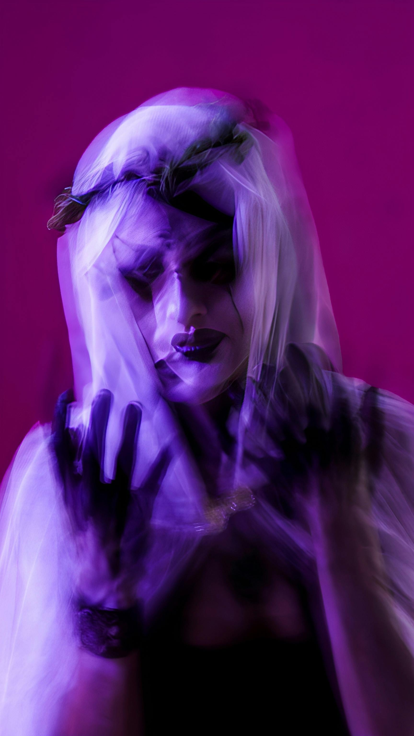 Abstract image of a ghostly figure with veil and dark makeup, vibrant purple glow.