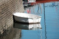 White rowboat moored beside a harbour wall — photo by Richard REVEL on Pexels